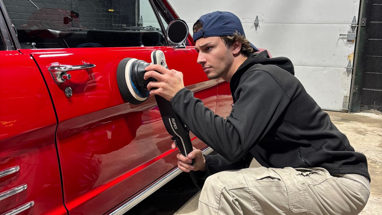 Car detailer working on a red car