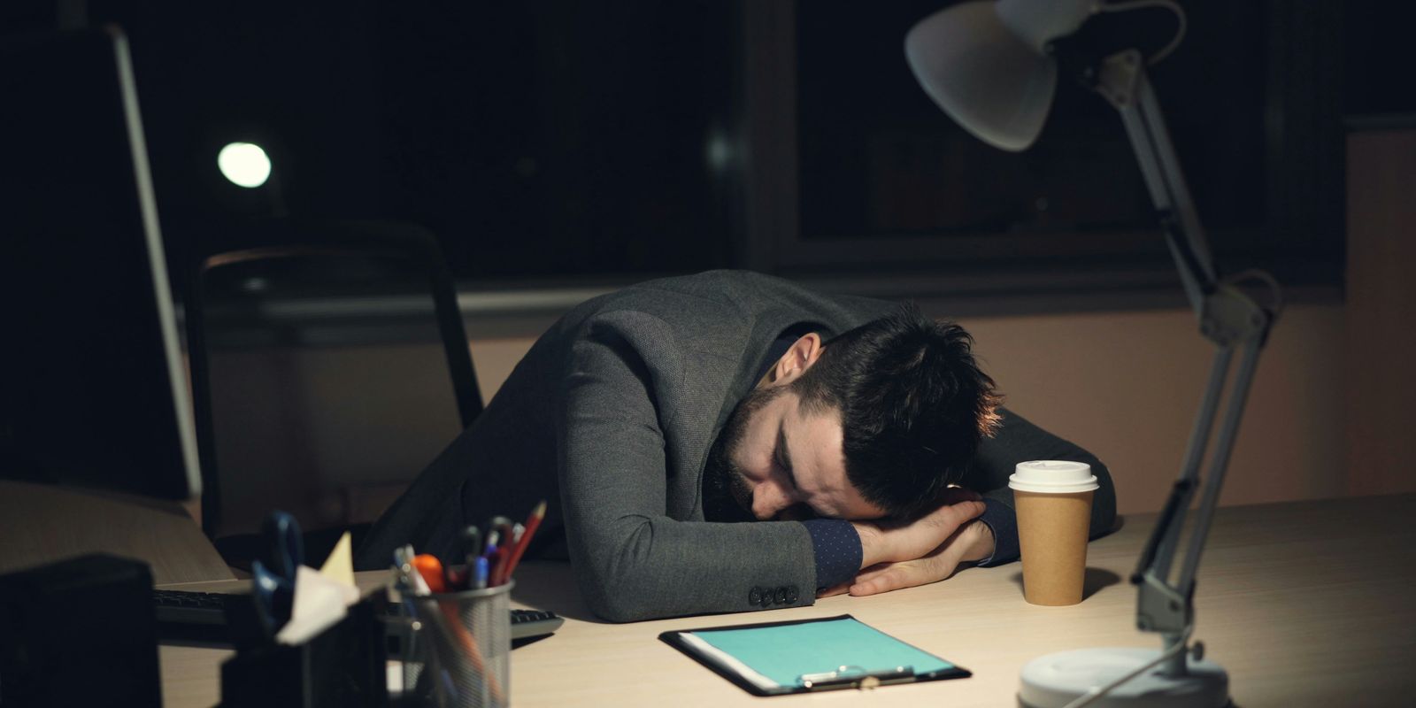 A man sleeping at the computer.