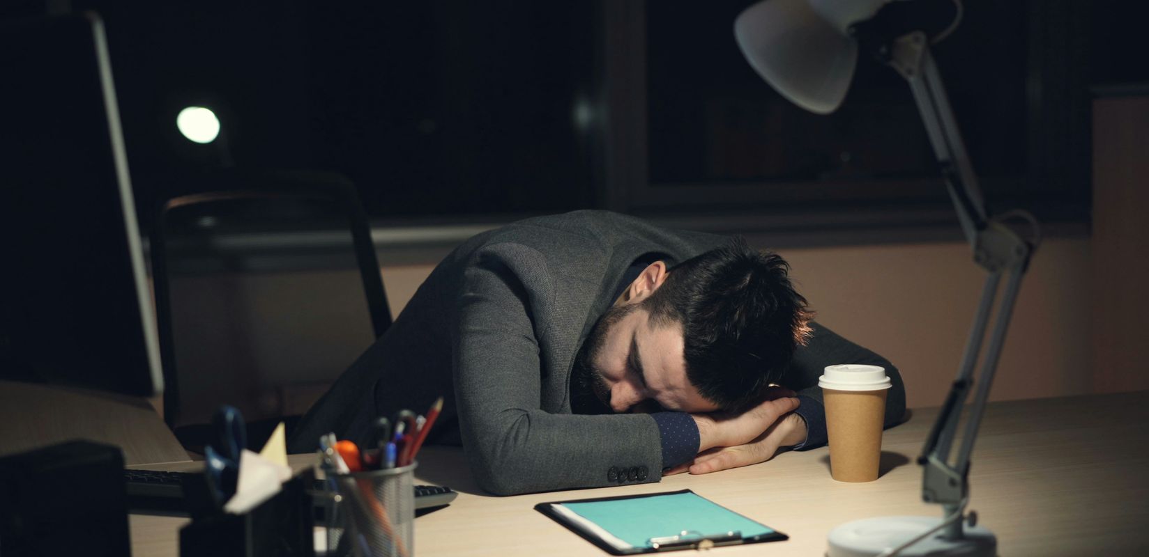 A man sleeping at the computer.