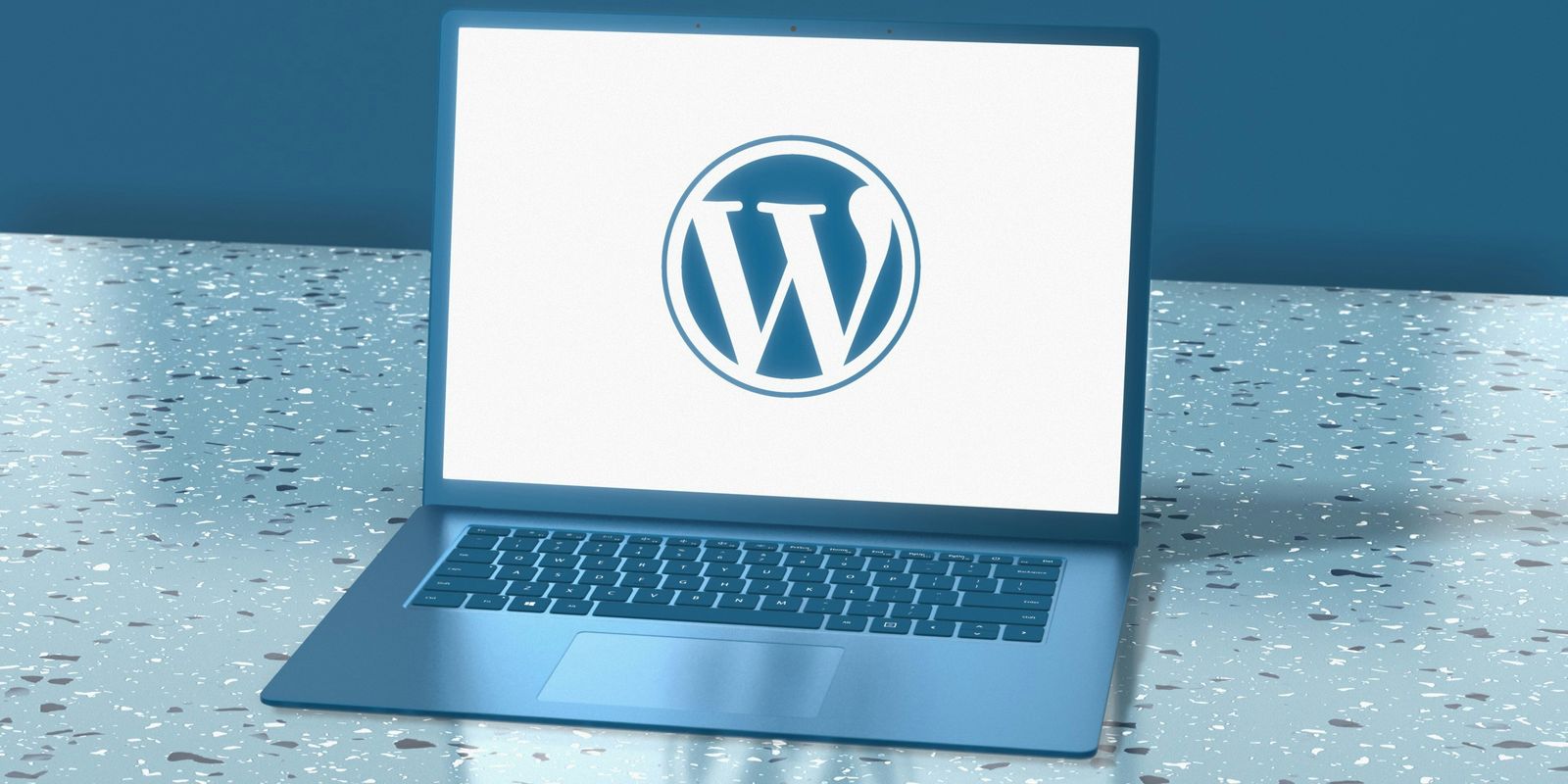 A laptop sitting on a table with a wordpress logo on the screen.