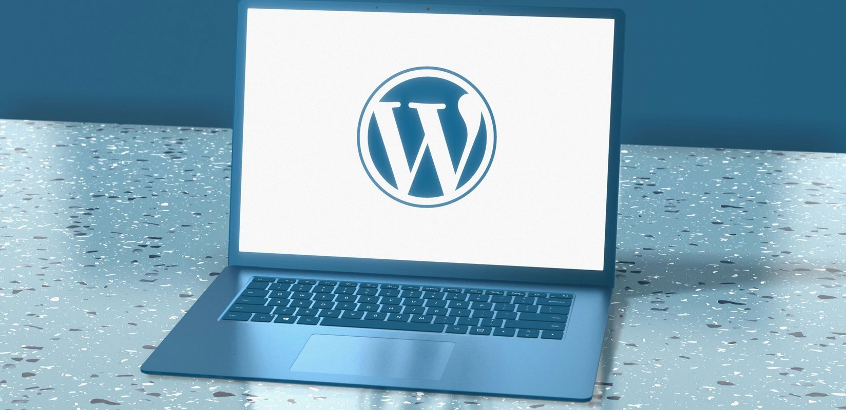 A laptop sitting on a table with a wordpress logo on the screen.